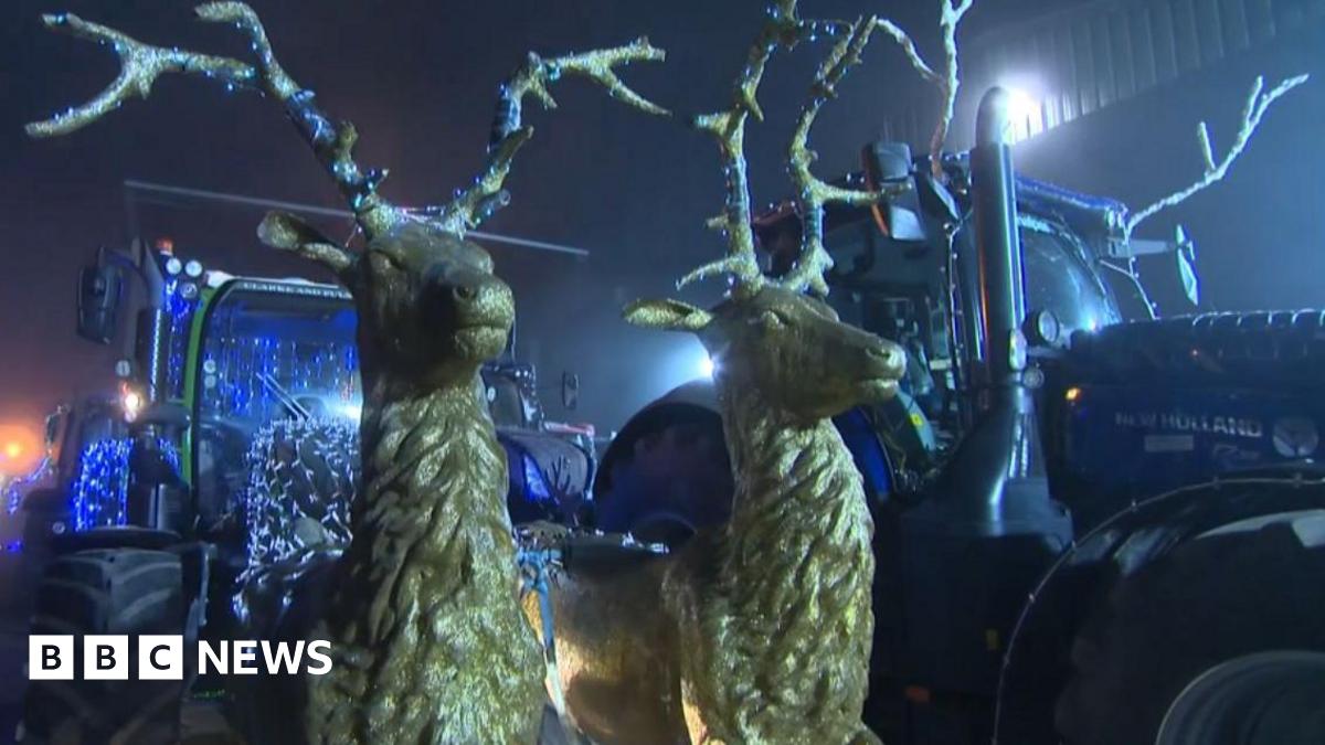 Two gold reindeer figures attached to a tractor as part of a Christmas parade display