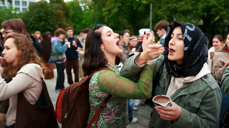 Participants eat pudding with forks at a pudding mit gabel gathering