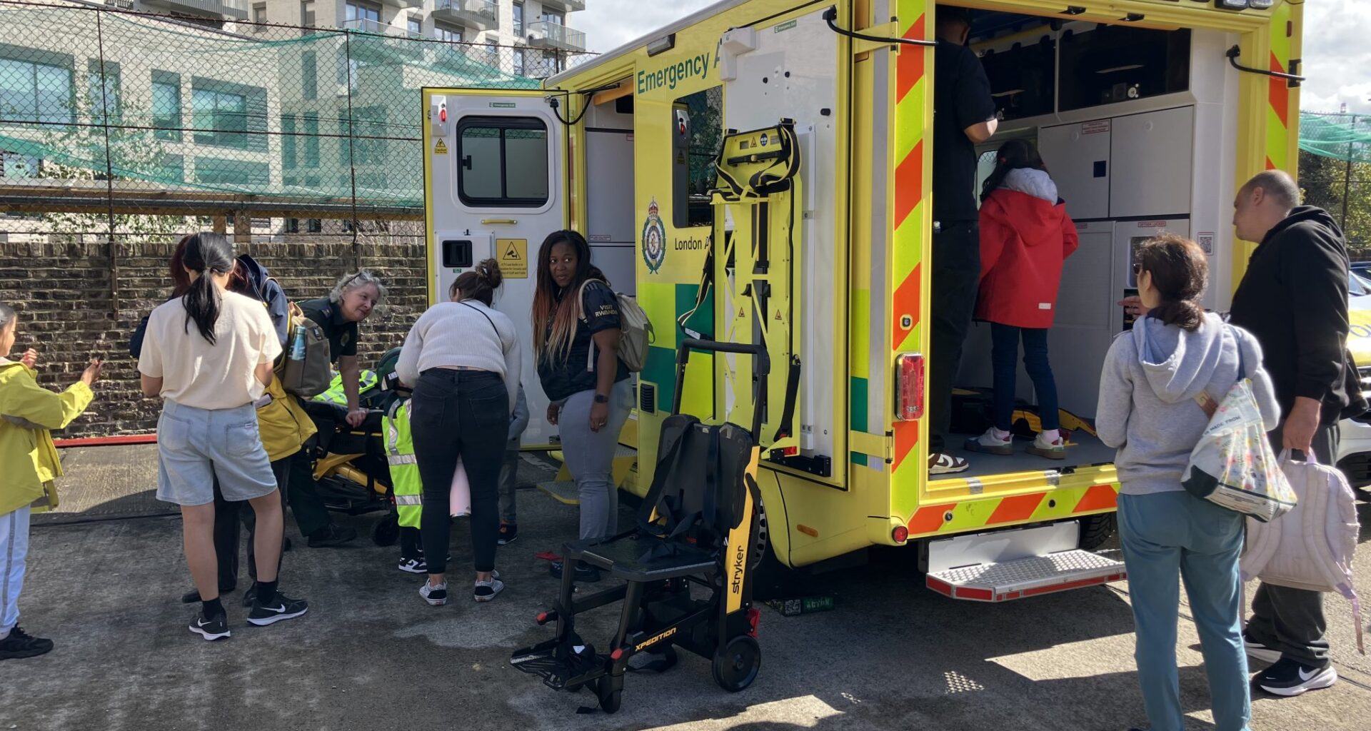 Community day at Acton Fire Station showing visitors exploring a London ambulance.