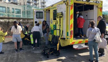 Community day at Acton Fire Station showing visitors exploring a London ambulance.