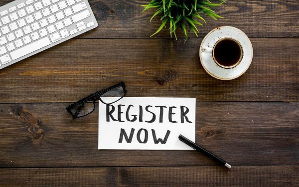 Register Now sign on a desk