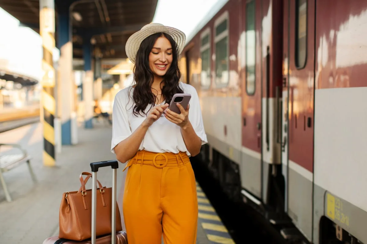 Woman with luggage boarding train in Europe