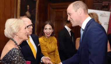 Prince William wearing a blue suit shaking hands with Mary Berry