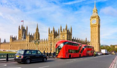 Double-decker buses and black cab on Westminster bridge with Big Ben and Houses of Parliament at background, London, UK