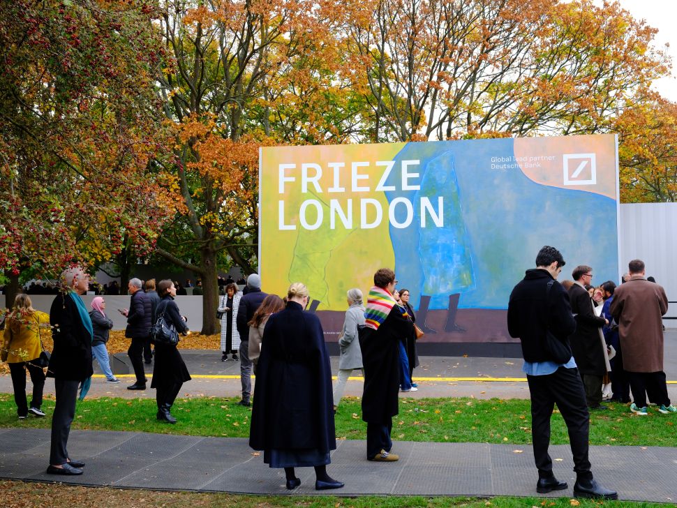 Crowds gathered in front of the large Frieze London entrance banner in Regent’s Park, surrounded by autumn trees with vibrant yellow and orange leaves.