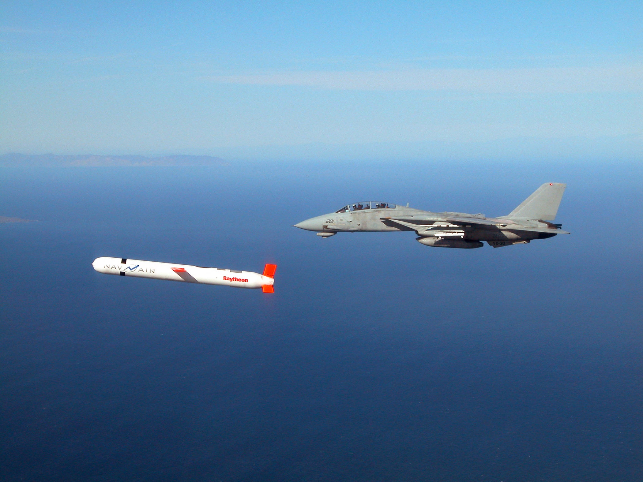 A Tactical ‘Tomahawk’ Block IV cruise missile is escorted by a Navy F-14 