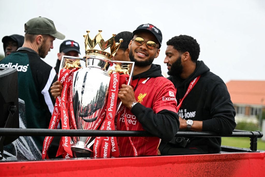 Liverpool's Dutch striker Cody Gakpo celebrates with the Premier League trophy during an open-top bus victory parade for Liverpool's Premier League title win, in Liverpool