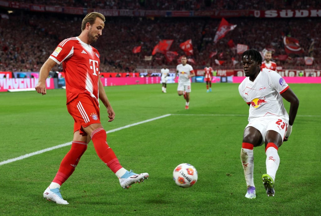 Bayern Munich's Harry Kane and RB Leipzig's Castello Lukeba during a Bundesliga match.