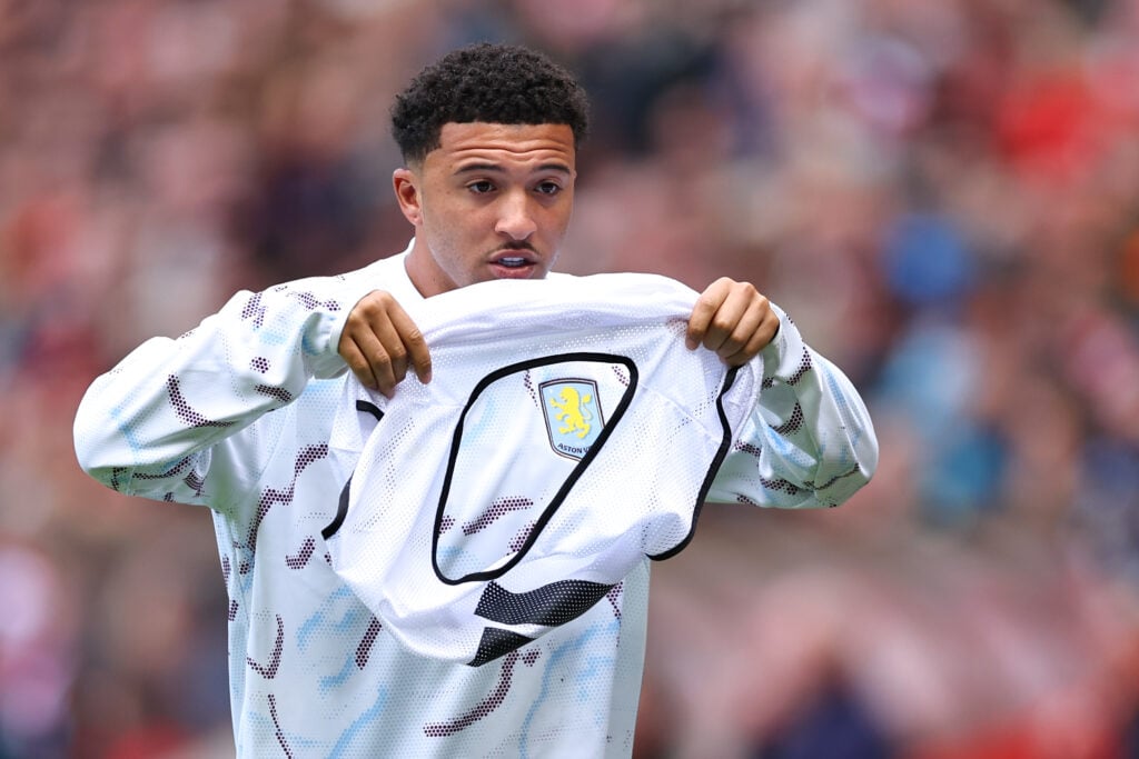 Jadon Sancho takes a substitutes bib at Aston Villa