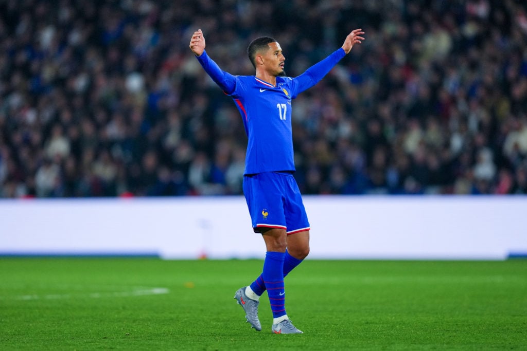 William Saliba has his arms in the air during a France game