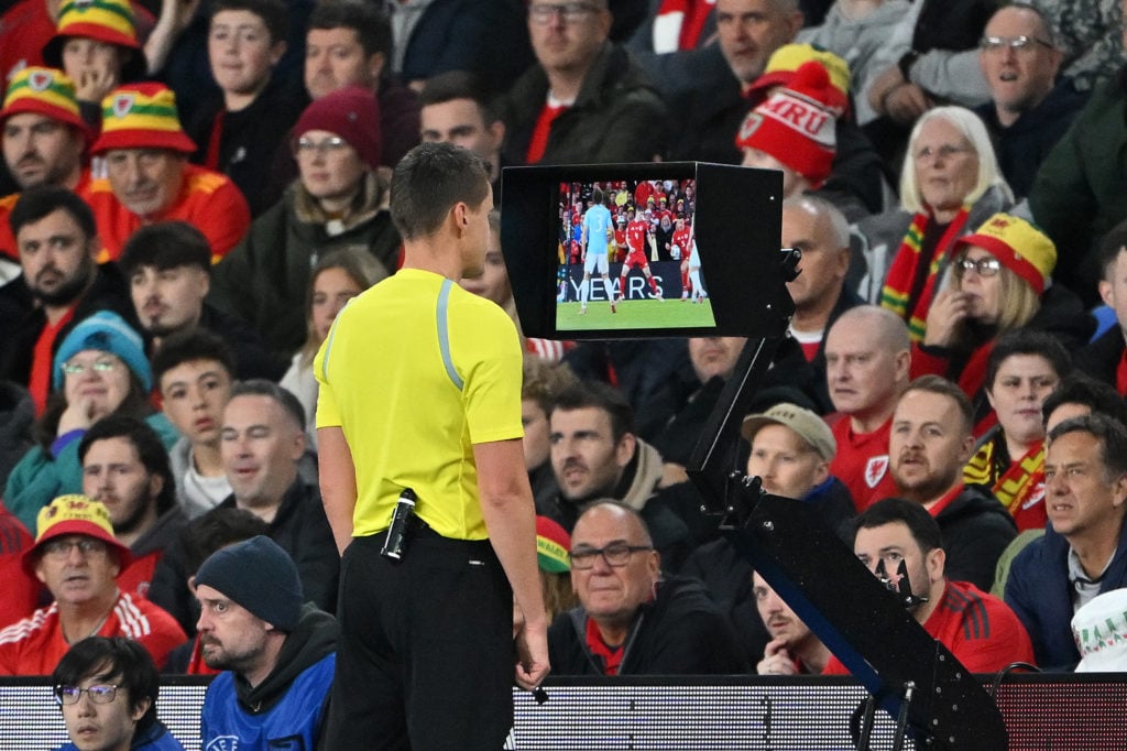 Referee checks a potential penalty against Ethan Ampadu for Wales