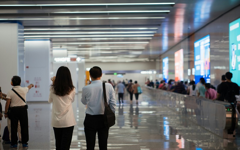People walking through an airport in Hong Kong. Photo by Shawn Rain on Unsplash