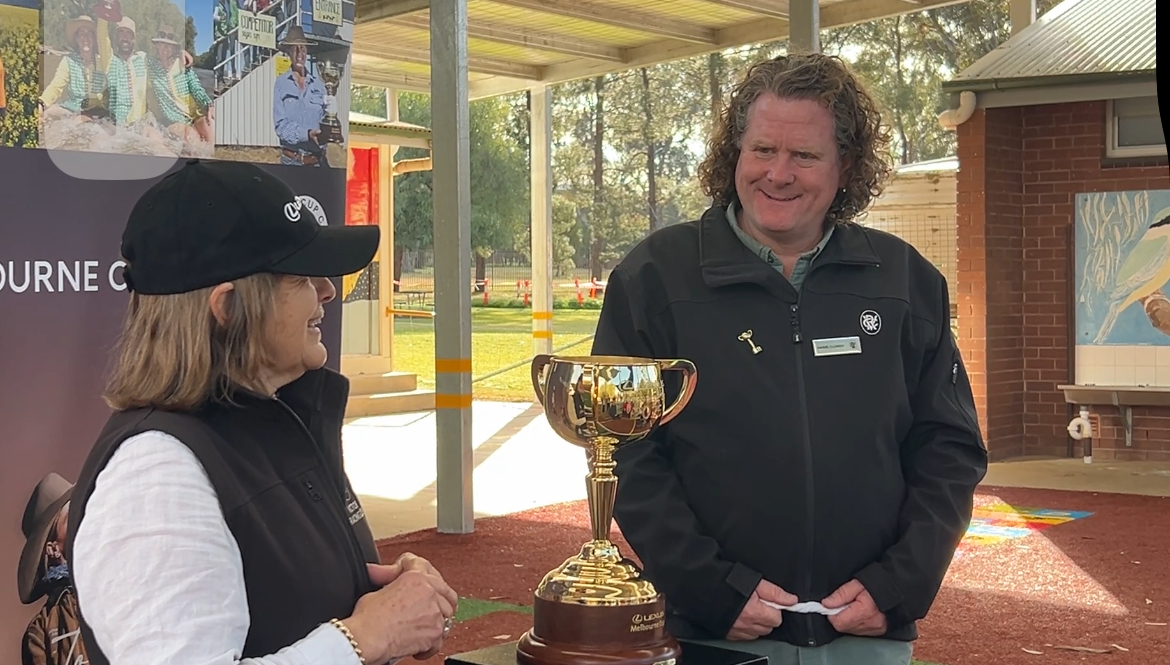 Dan Closehy from the Victorian Racing Club introduces the 2024 Melbourne Cup winning trainer, Sheila Laxon, to those who gathered at Burrumbuttock Public School to celebrate its appearance.