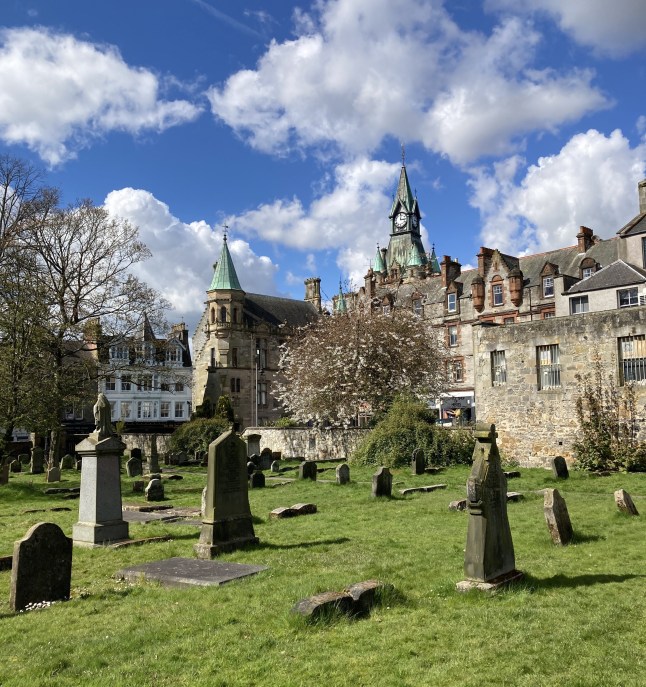 Historic graveyard in Dunfermline, Scotland, on a bright, cloudy day