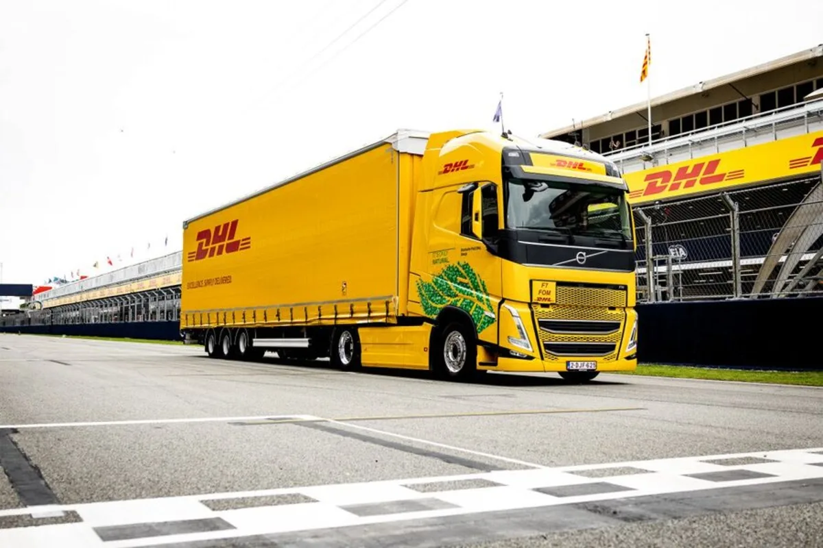 A yellow DHL truck on a race track