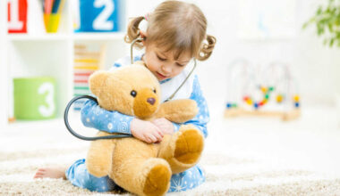 child playing doctor with teddy bear