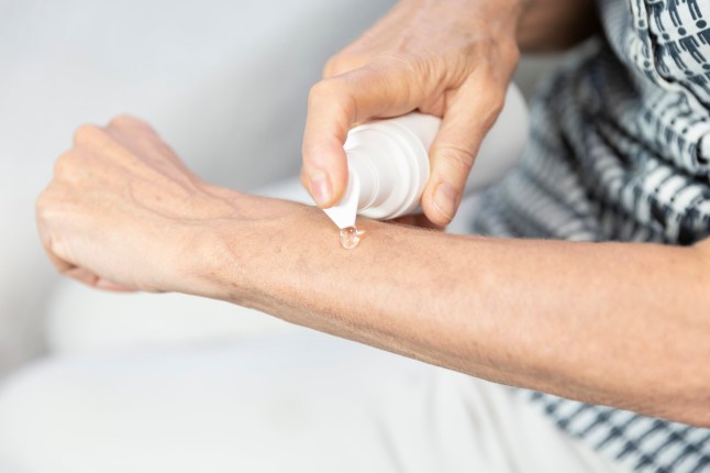 Woman applying post-menopause hormone gel.