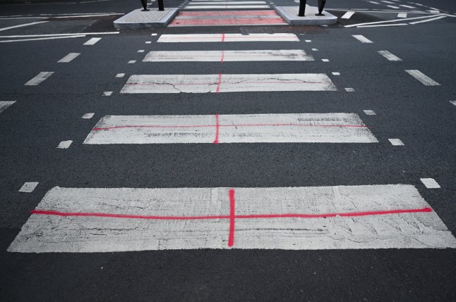 LONDON, UNITED KINGDOM - AUGUST 28: A view of St. George's Crosses painted on pedestrian walkways as part of the 'Operation Raise the Colours' campaign in the Tower Hamlets area east of London, United Kingdom on August 28, 2025. The campaign is seen as a sign of patriotism by its supporters, while its opponents criticize it for carrying anti-immigrant messages. (Photo by Rasid Necati Aslim/Anadolu via Getty Images)