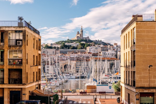A view of Marseille's Old Port with boats on the water, taken between two buildings