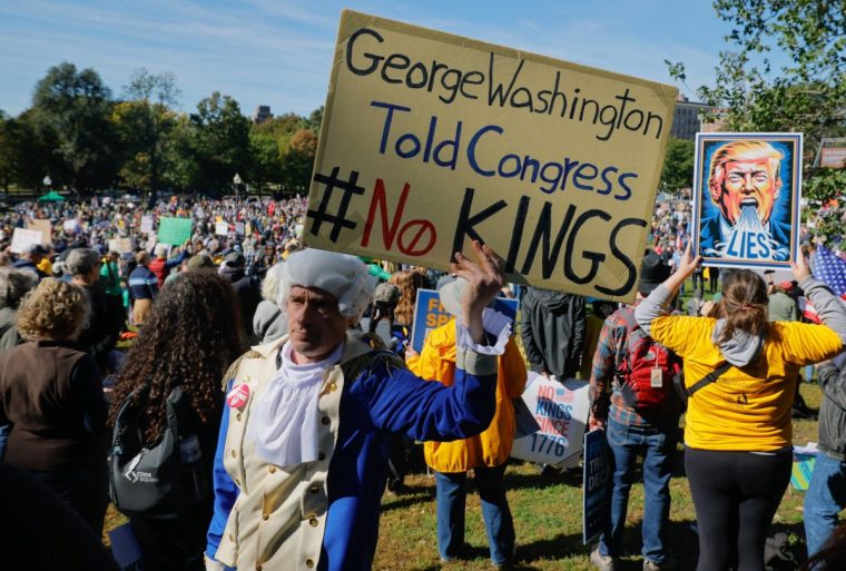 A man dressed as former U.S. President George Washington displays a sign during a "No Kings" protest against U.S. President Donald Trump's policies in Boston, Massachusetts, U.S., October 18, 2025. REUTERS/Brian Snyder