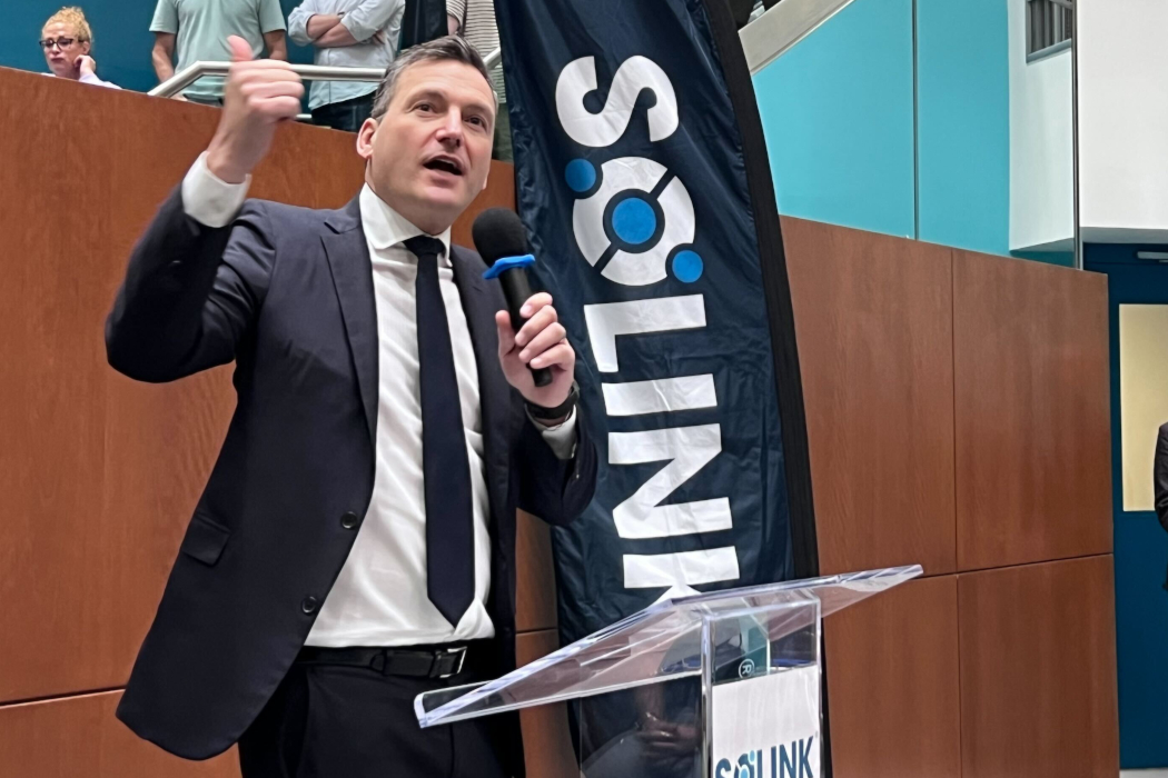 Evan Solomon speaks into a microphone while gesturing his hand.