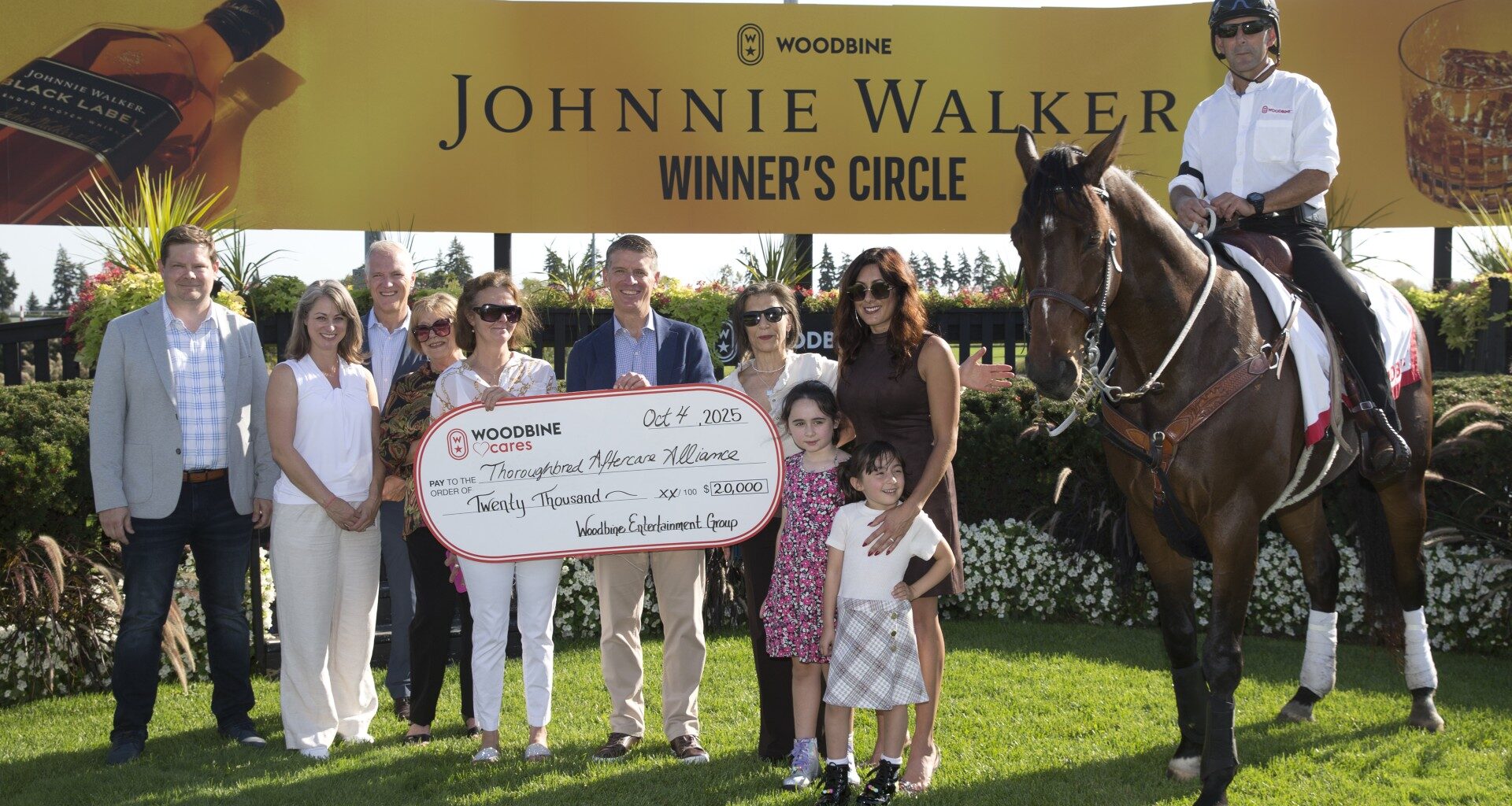 Michael Copeland, CEO of Woodbine, makes a presentation to Vicki Pappas, chairperson and founding member of LongRun, local trainer and volunteer Liz Elder, and Thoroughbred Aftercare Alliance’s Stacie Clark Rogers and Emily Dresden and Emily’s daughters Aria and Lainey. (Michael Burns Photo)