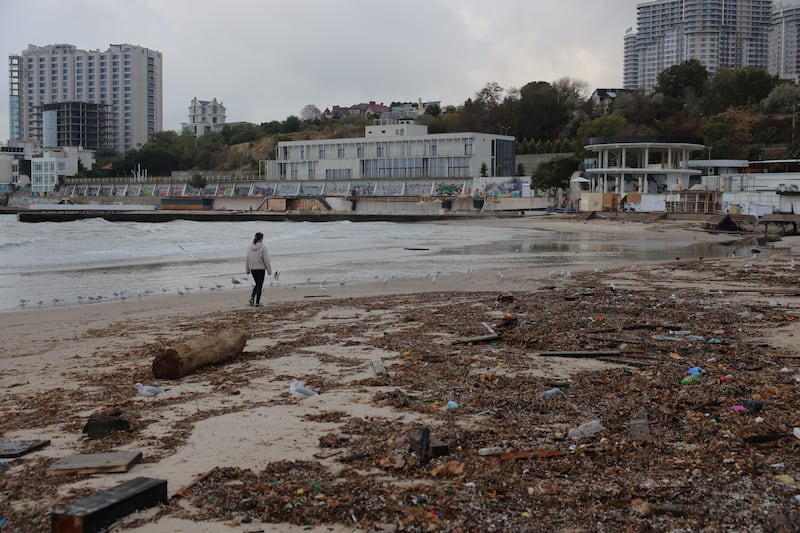 A woman walks past rubbish and debris strewn along a beach following a severe rainstorm in Odesa, on October 1st. Photograph: Oleksandr Gimanov/AFP via Getty