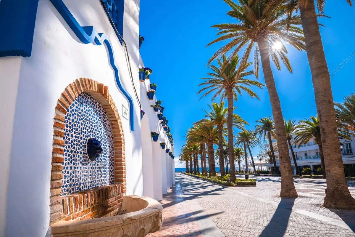 Whitewashed facades and rows of palm trees in Nerja, Spain