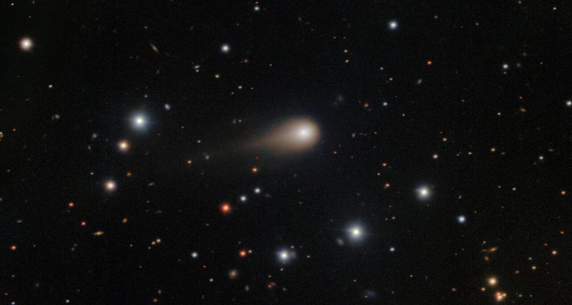 a photo of the comet 3I/ATLAS with its long tail shooting through space