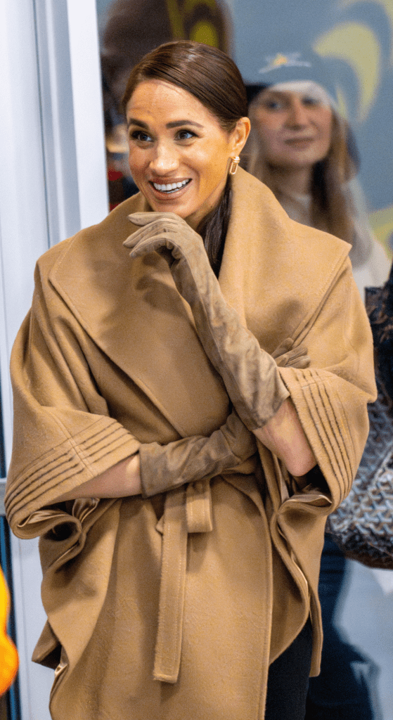 Meghan Markle wearing a brown coat and brown gloves