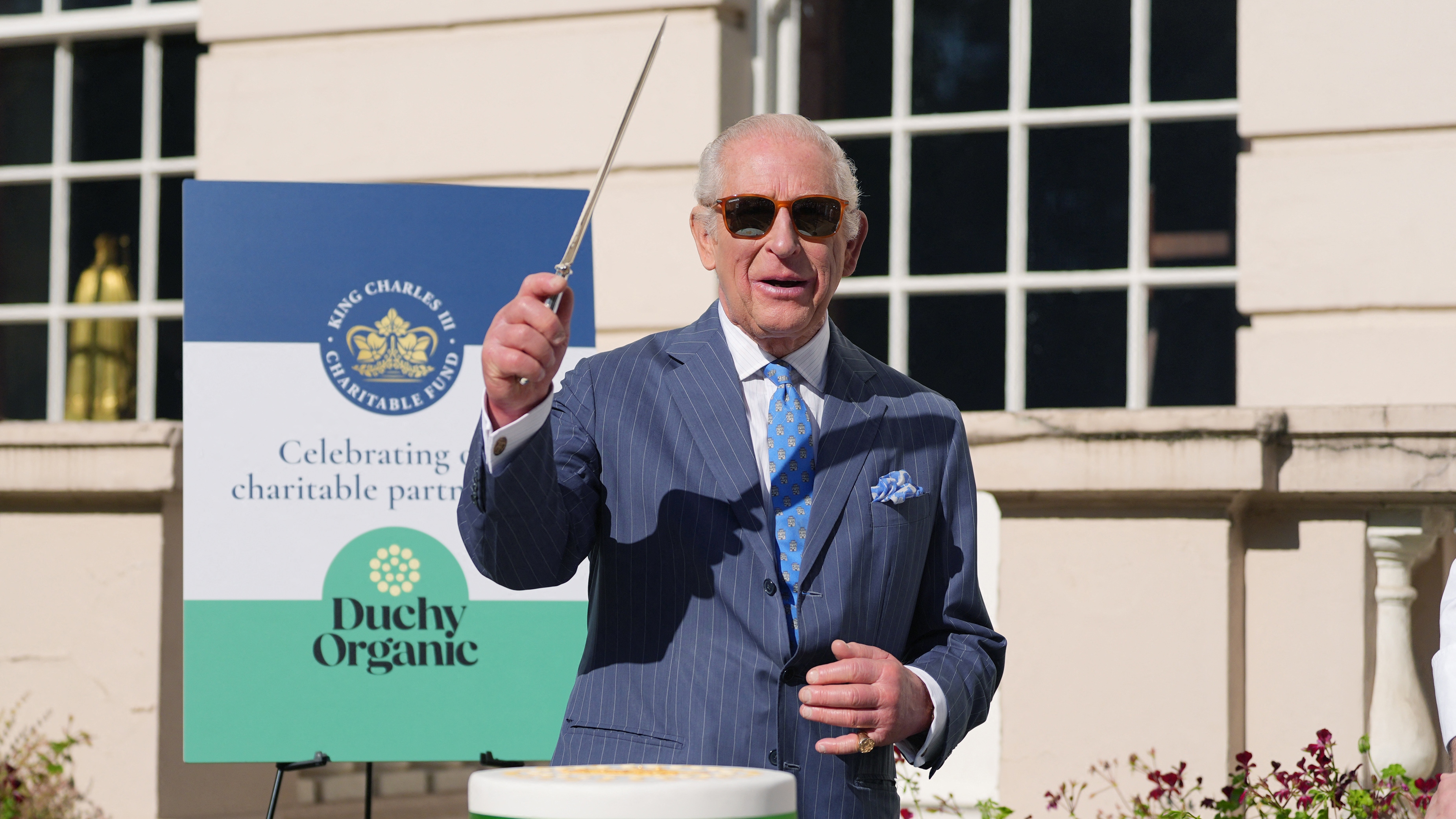 King Charles III cuts a cake, made from Duchy Organic ingredients, during a reception for King Charles III Charitable Fund (KCCF)