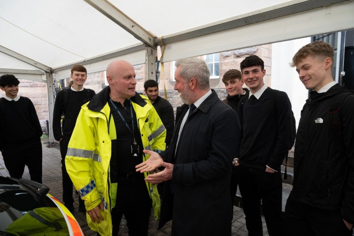 Transport and environment convener, Councillor Stephen Jenkinson speaks to a police officers with school children waiting behind (C) The City of Edinburgh Council