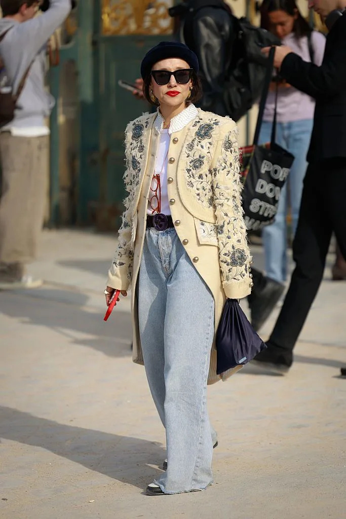 paris, france october 01: a guest is seen wearing navy hat, white shirt, gucci belt, ivory and green embellished jacket and jeans outside christian dior during the womenswear spring summer 2026 as part of paris fashion week on october 01, 2025 in paris, france. (photo by hanna lassen/getty images)