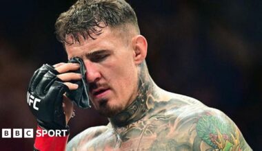 Tom Aspinall dabs his eye after suffering an eye poke during his fight with Cyril Gane at UFC 321