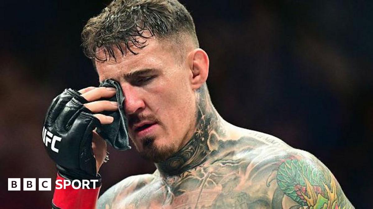 Tom Aspinall dabs his eye after suffering an eye poke during his fight with Cyril Gane at UFC 321