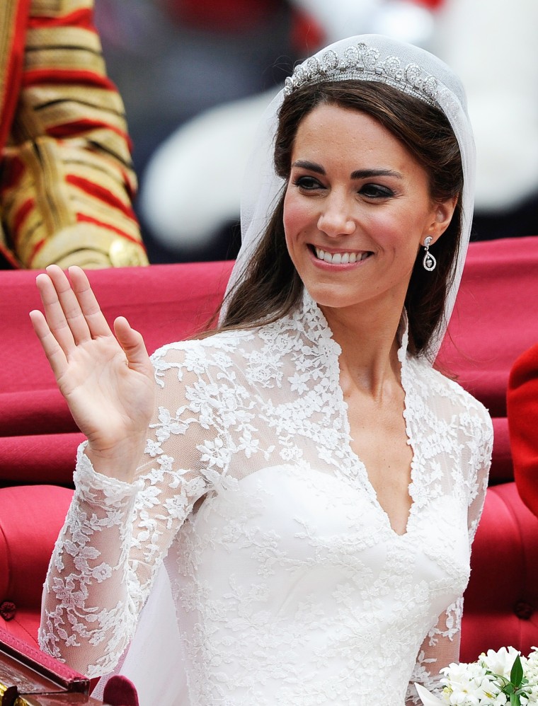 Catherine, Duchess of Cambridge waves as she travels beside husband Prince William, Duke of Cambridge after their wedding ceremony.