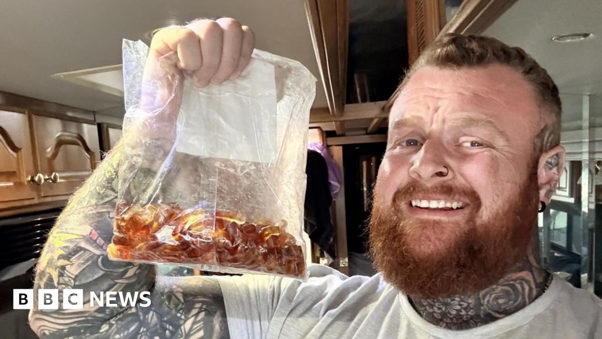 Nathan Rimmington holds up a bag of cola bottle sweets.