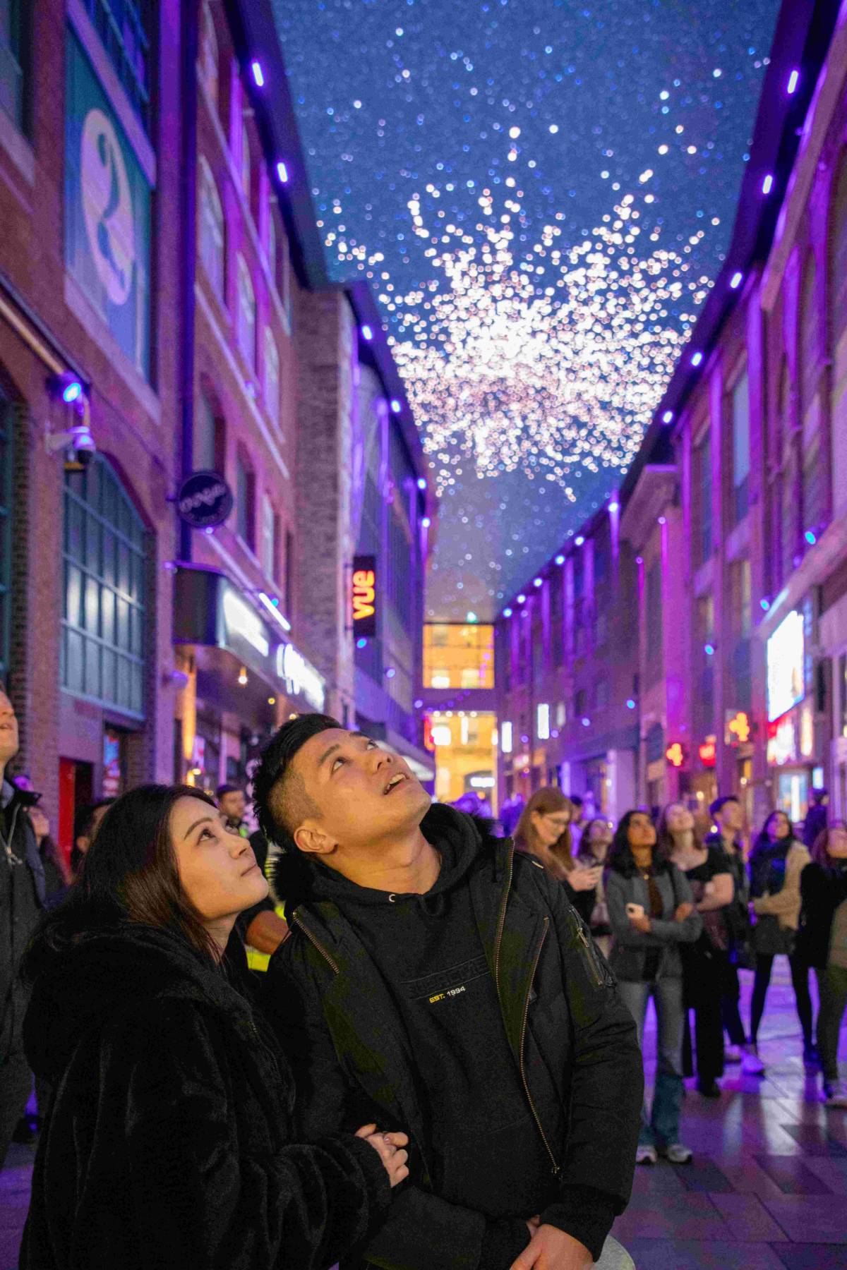 couple looking up at fireworks on digital ceiling