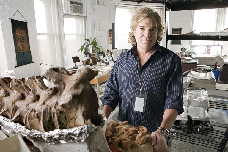 A portrait of palaeontologist Mark Norell with fossils at his museum office.