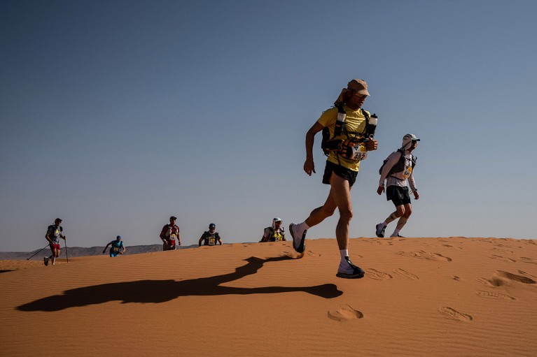 Competitors race over a sand dune during a marathon in the southern Moroccan Sahara desert.