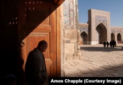 A man walking through the Registan of Samarkand.