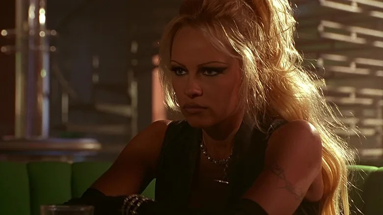 Barb sitting in a resaturant booth in Barb Wire