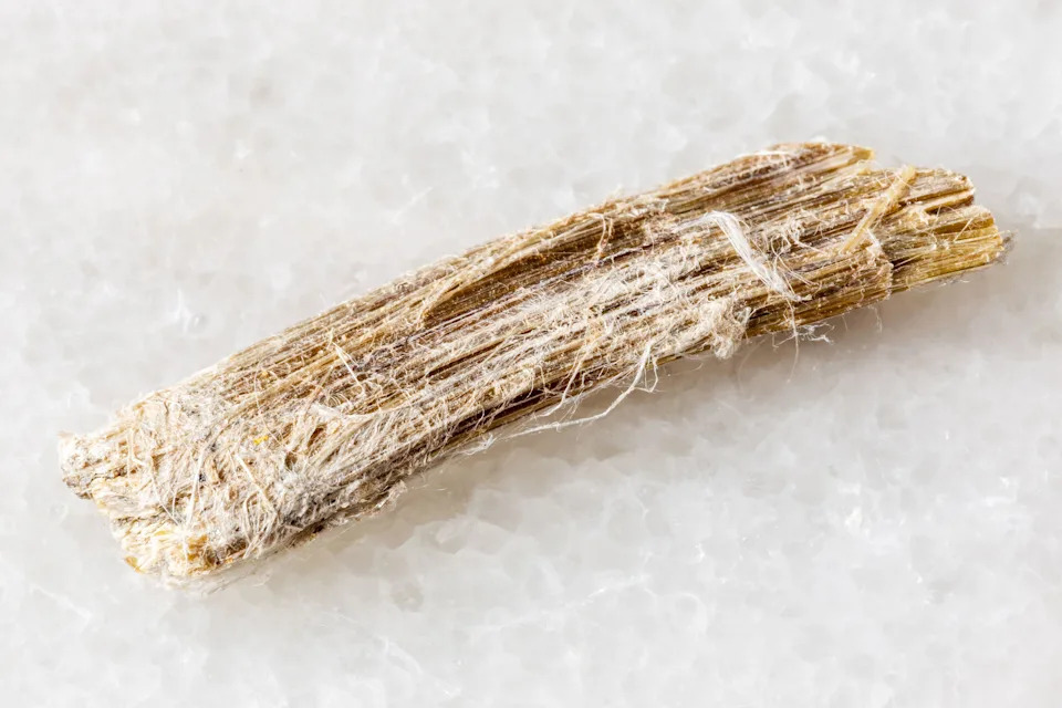 sample of rough chrysotile asbestos mineral on white marble background close up from Canada, Quebec