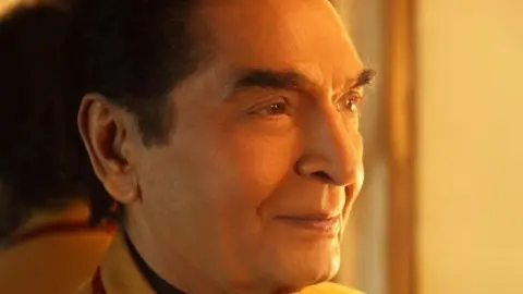 Asrani/Facebook A man looks away from the camera as yellow light falls on him