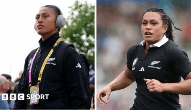 Liana Mikaele-Tu'u dressed in New Zealand-branded black training top, yellow and pink lanyard and grey headphones