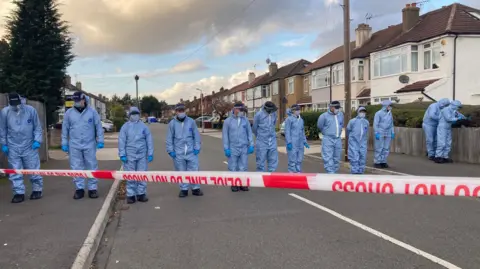 PA Media Forensic officers at the scene in Midhurst Gardens in Uxbridge.