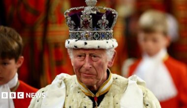 King Charles wears a bejewelled crown and a large fur robe.