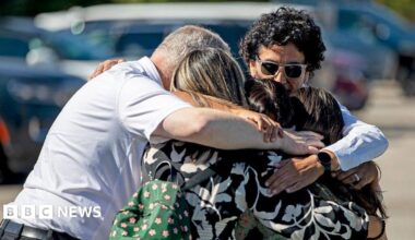 A family of five is seen embracing as they emotionally reunite at the Trillium Theater, located across the street from the site of a shooting and fire at the Church of Jesus Christ of Latter-day Saints on September 28, 2025 in Grand Blanc, Michigan.