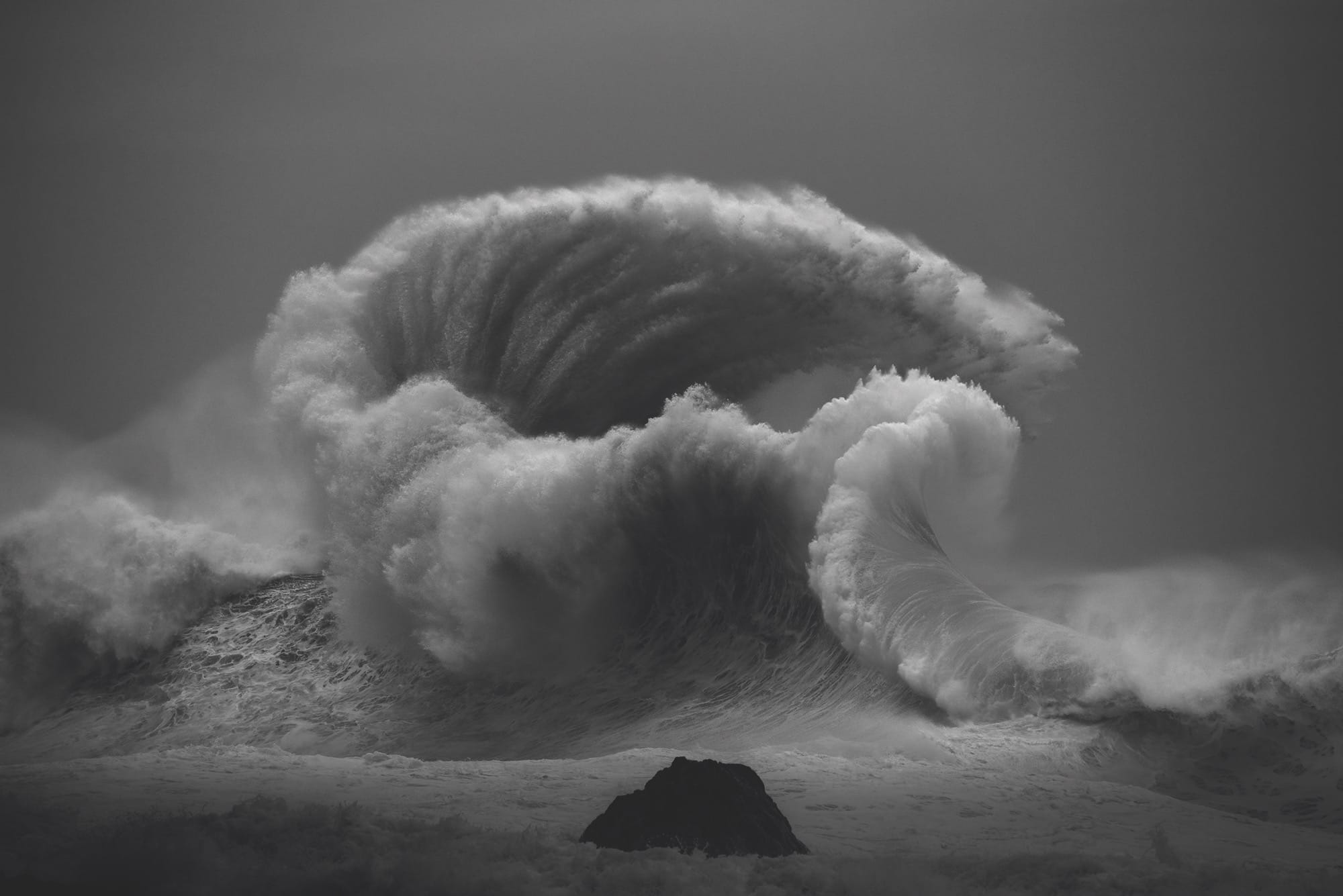 a black-and-white photo by Luke Shadbolt of a wind-swept, huge wave