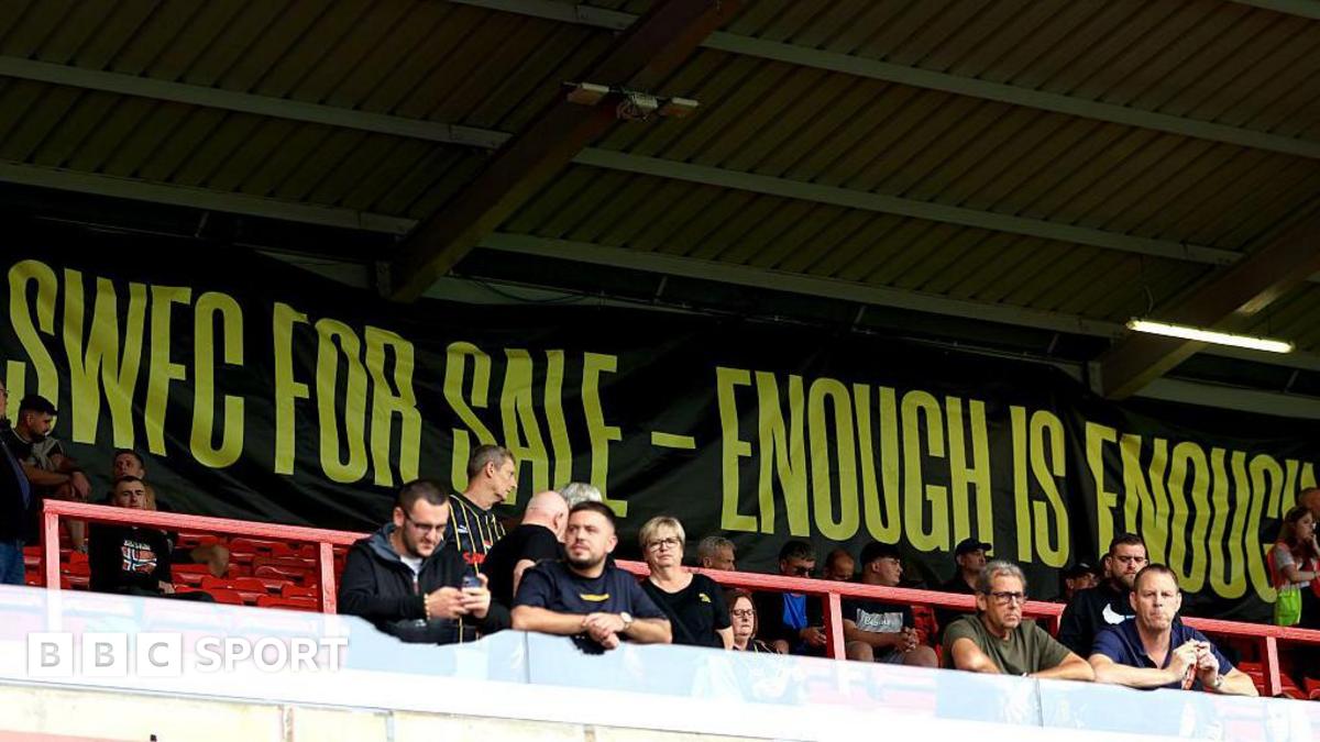 Sheffield Wednesday supporters stand in front of a banner that reads 'SWFC for sale - enough is enough'